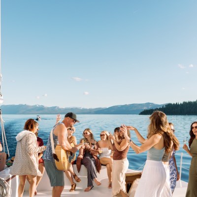 Group of people enjoying a party on a boat with a clear blue sky.