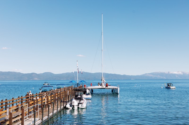 Dock with boats on a calm lake under a clear blue sky.