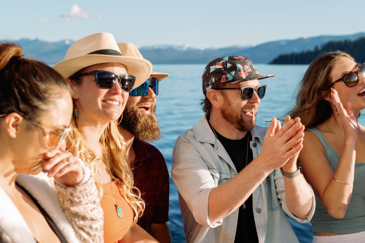 Group of people on a boat, enjoying a sunny day on the water.