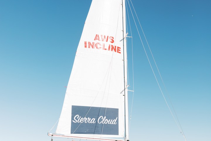 Sailboat 'Sierra Cloud' on calm water with people on board.